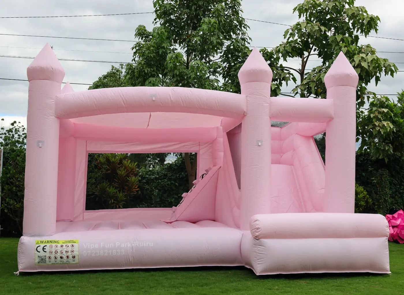 A soft pink bouncing castle with an interior climbing section and slide at Vipe Fun Park