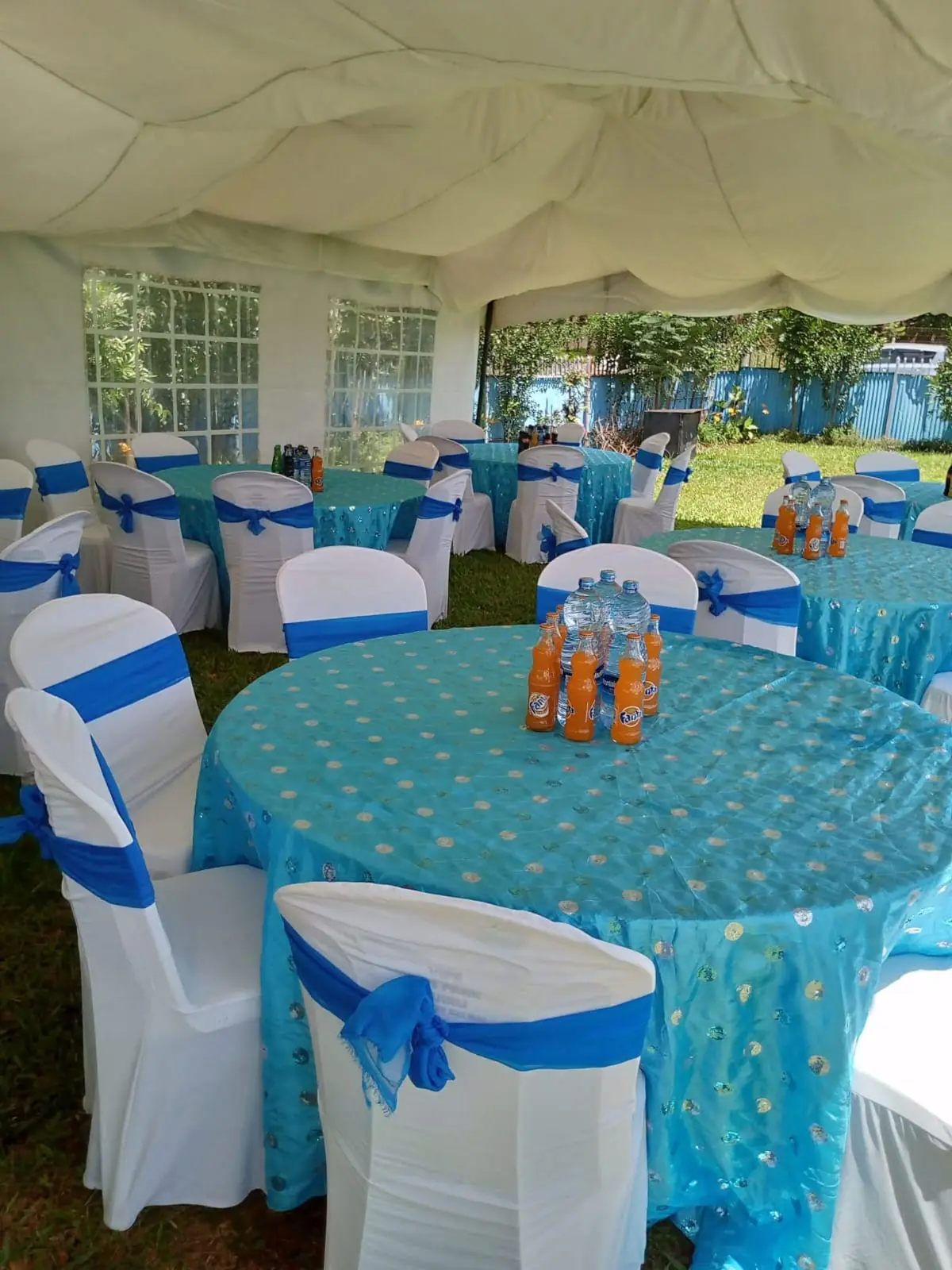 Round tables with blue covers and dressed chairs under a marquee tent at Vipe Fun Park