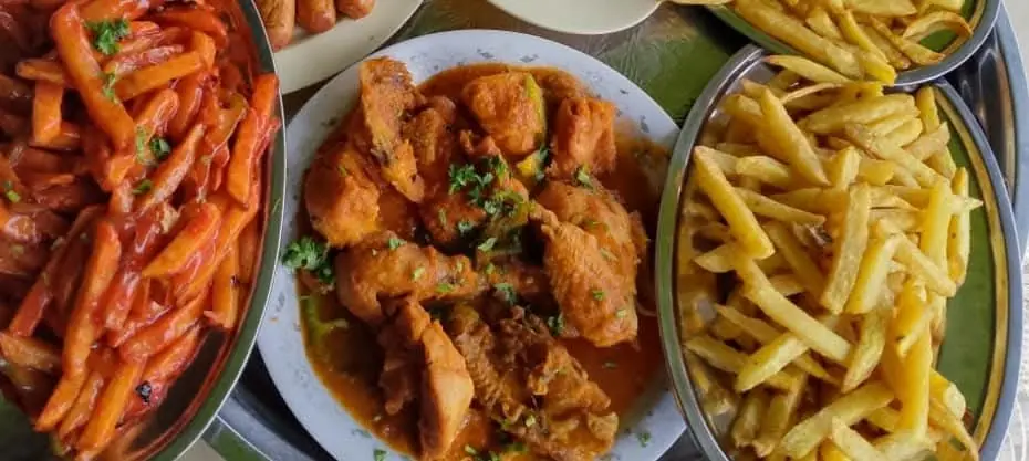 Chicken stew served with bowls of chips and sauced potatoes at Vipe Fun Park
