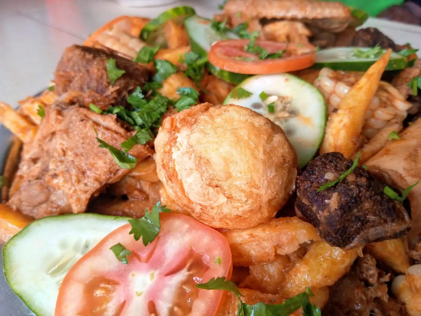 A close view of fried snacks, chips, maize, tomato and cucumber on a shared plate at Vipe Fun Park