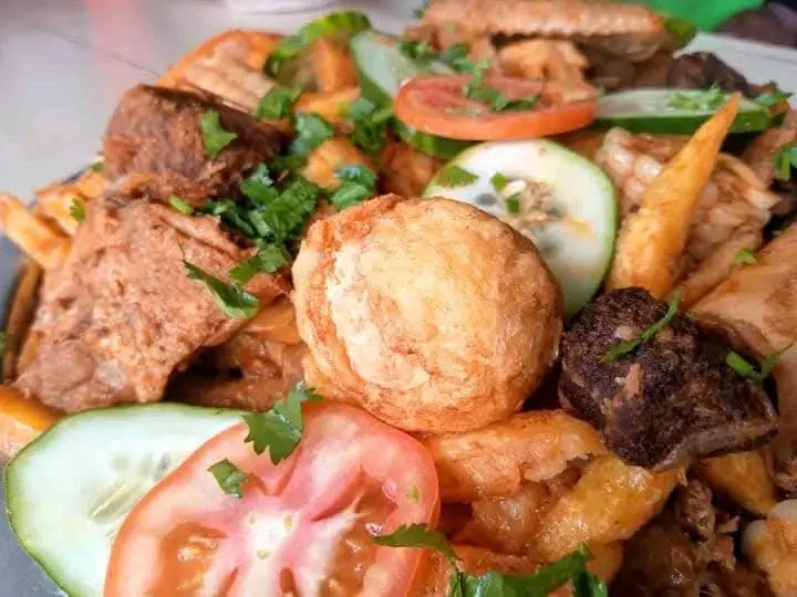 Fried meat, chips, tomato and cucumber served together on a plate at Vipe Fun Park
