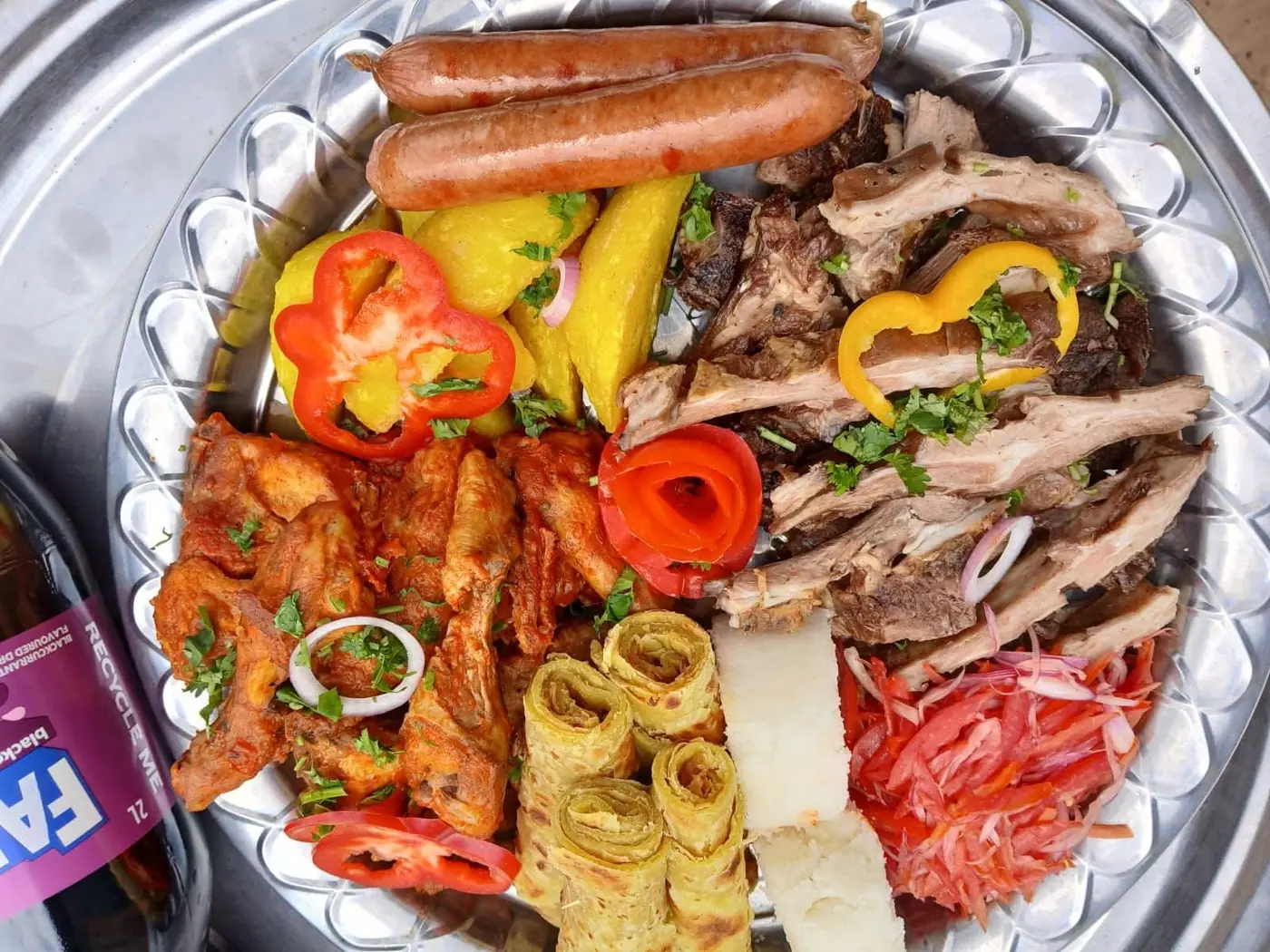 A large sharing platter of grilled meats, sausages, chapati, ugali and fresh salad served at Vipe Fun Park
