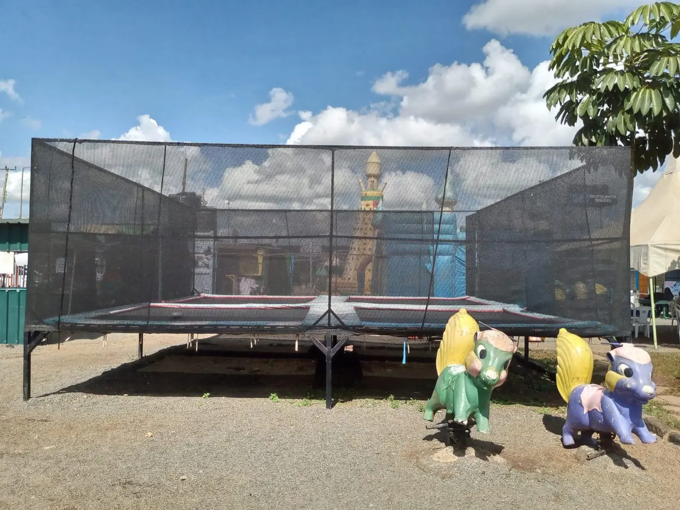 A large netted trampoline beside colourful spring rockers at Vipe Fun Park