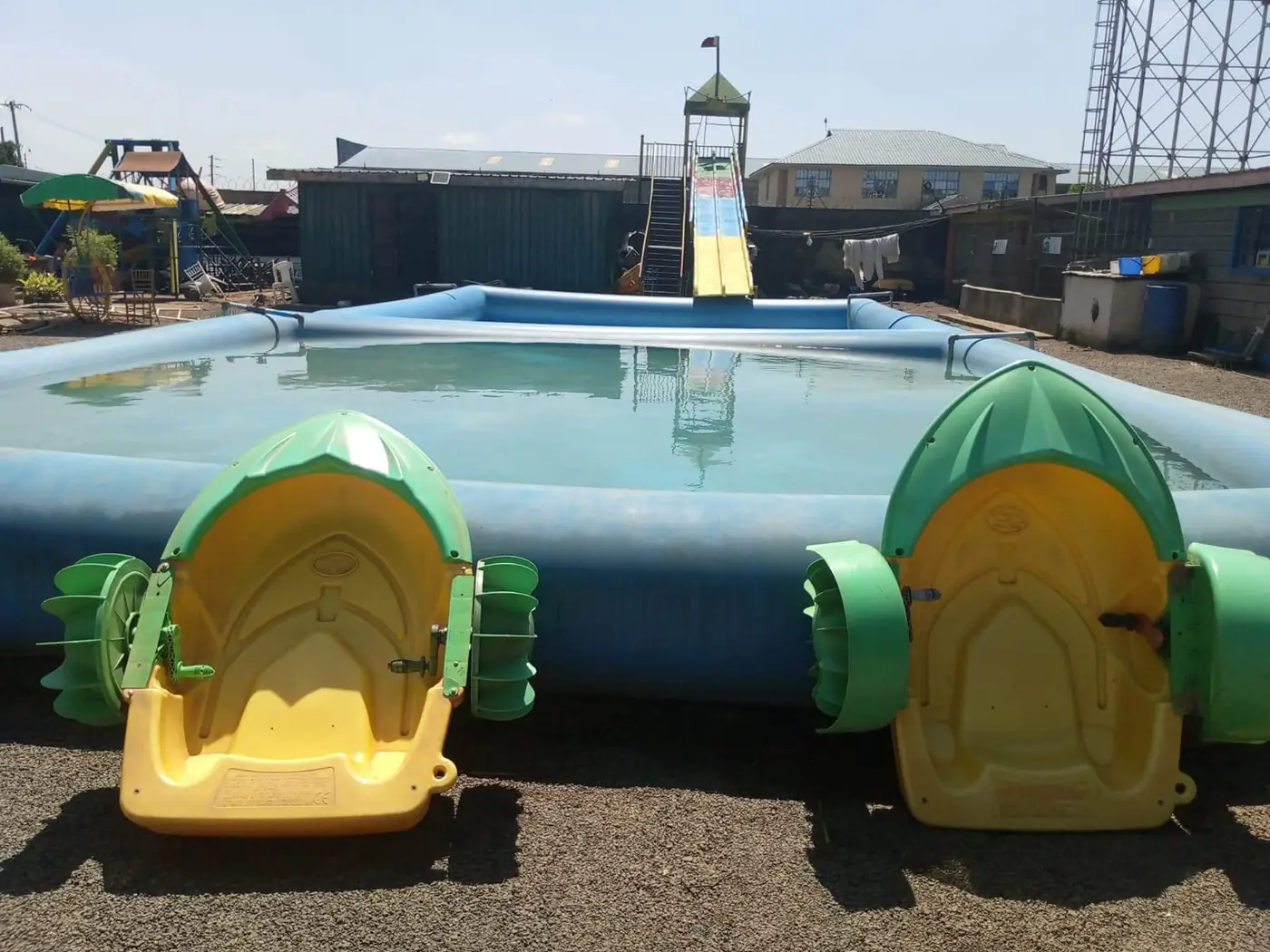 Green and yellow paddle boats beside the pool and water slide at Vipe Fun Park